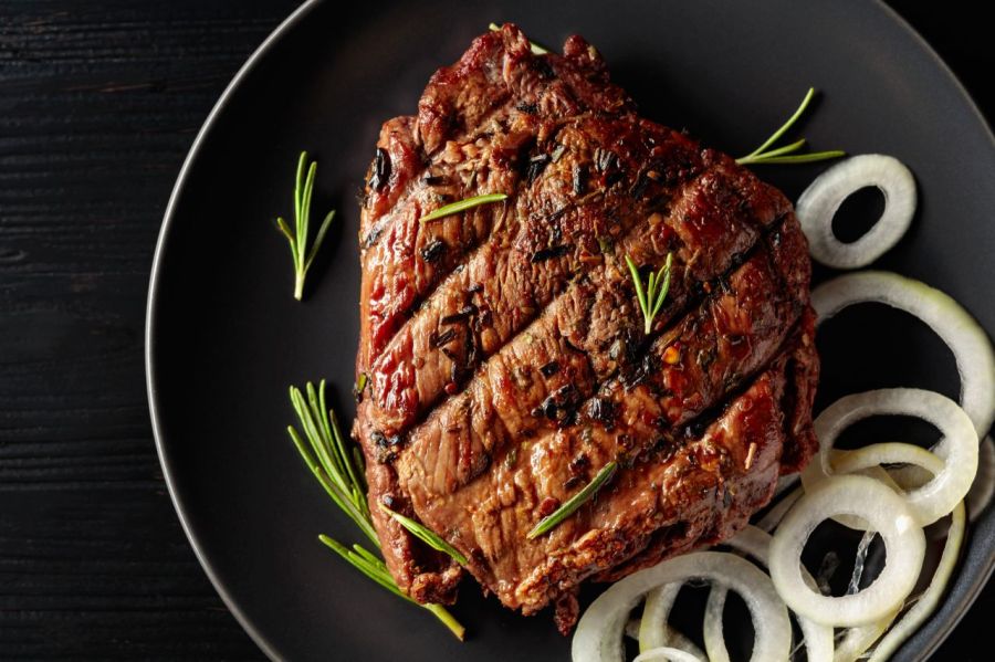 Carne grelhada com cebolas servida no prato