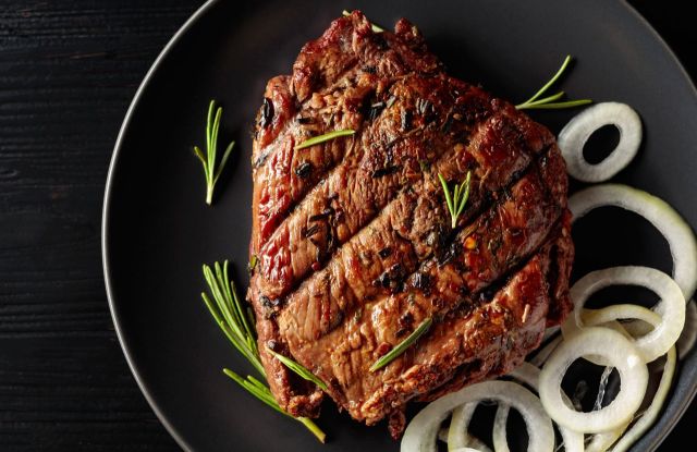 Carne grelhada com cebolas servida no prato