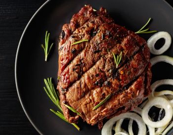 Carne grelhada com cebolas servida no prato